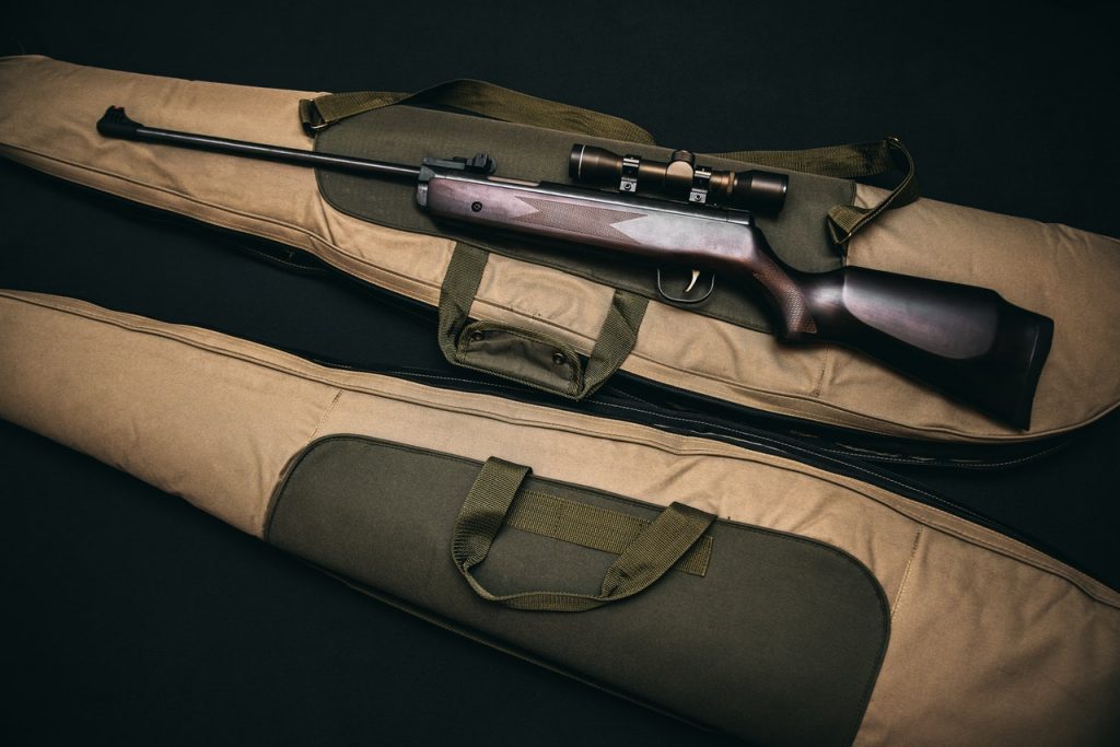 A rifle and its case displayed on a black background, highlighting their features and design.